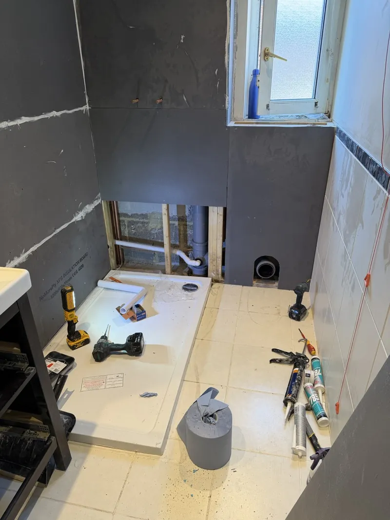 The same bathroom mid-build, with new boards and plumbing